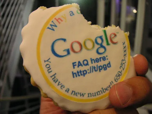 Een hand houdt een koekje vast met het Google-logo en enkele promotionele teksten erop gedrukt