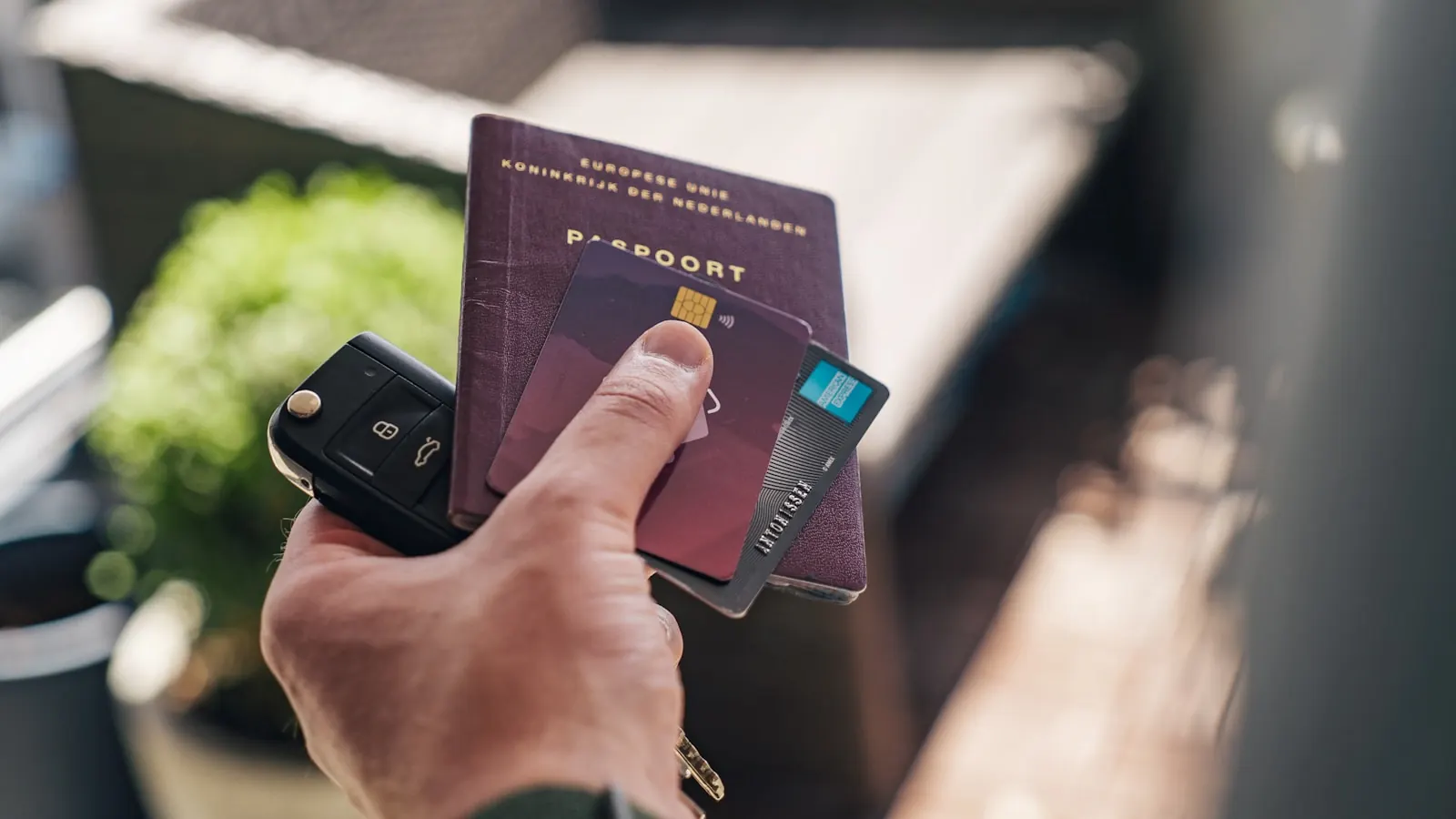 Hand houdt een paspoort en een bankkaart vast, klaar voor reizen.