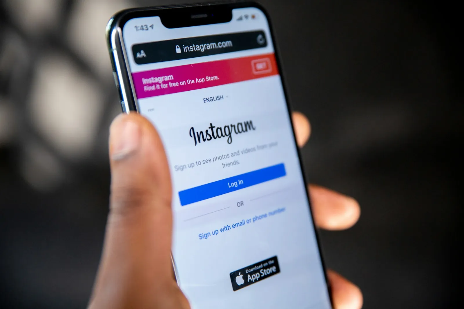 Een persoon houdt een smartphone vast met het inlogscherm van Instagram open in de webbrowser