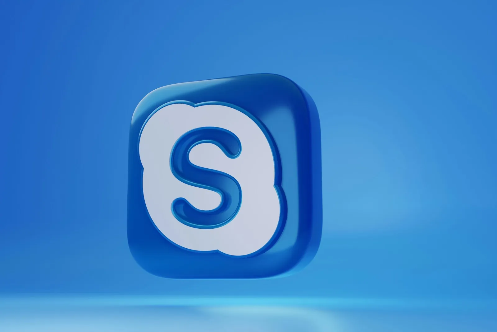 3D pictogram van Skype in een glanzende blauwe tint tegen een monochroom blauwe achtergrond